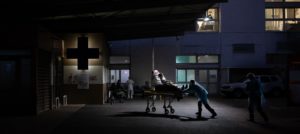 Un malade en détresse respiratoire, suspecté d'être atteint du COVID 19, est amené sur un brancard aux urgences par les pompiers.